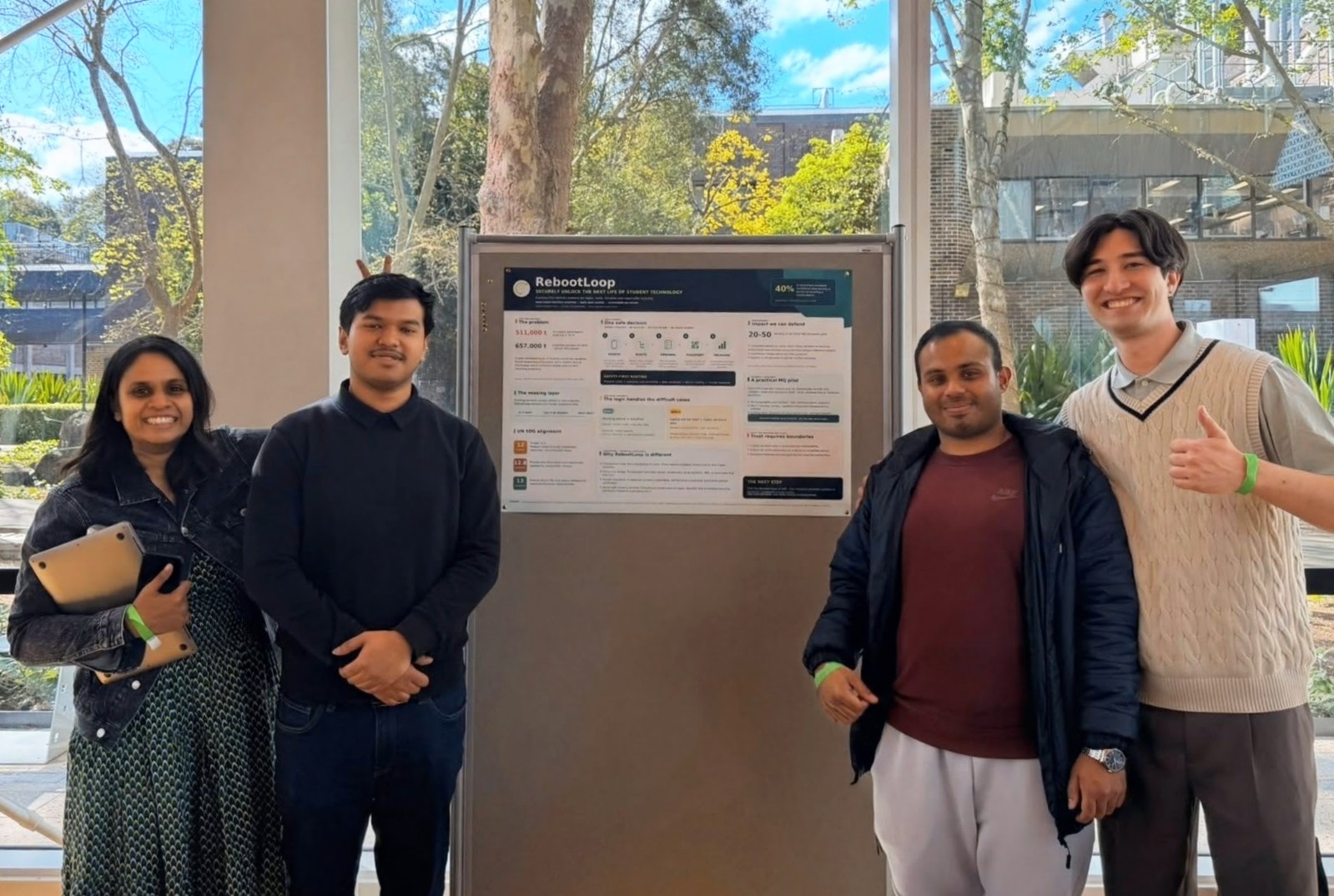 The RebootLoop team standing beside their competition poster at Pitch for the Planet 2026.